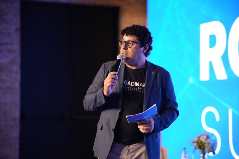 Jose JR al micrófono en el Roadmap Summit, con blazer y camiseta del evento