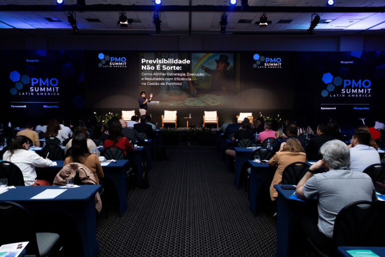 Jose JR dando una conferencia en el escenario del PMO Summit Latin America, con el público completo